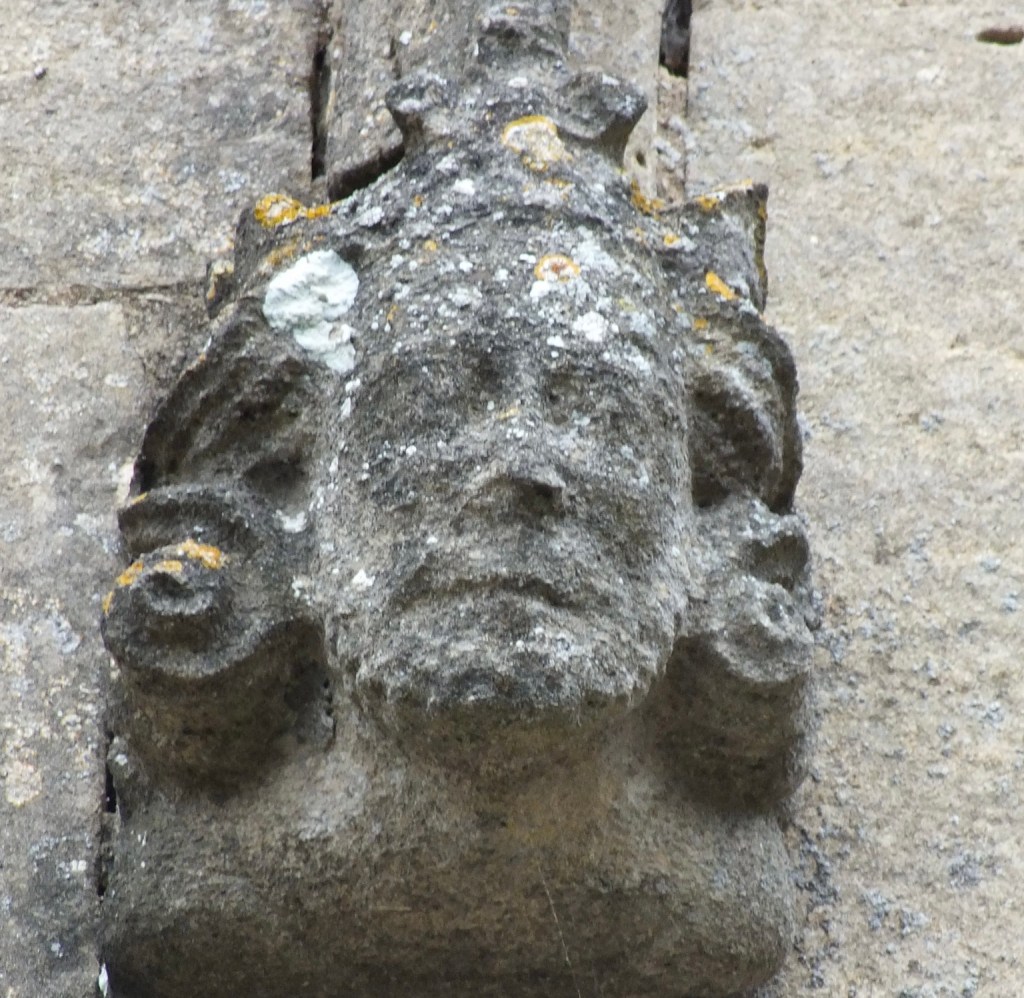 Weathered carved crowned head on the exterior stonework of St Andrew's Church, Heckington