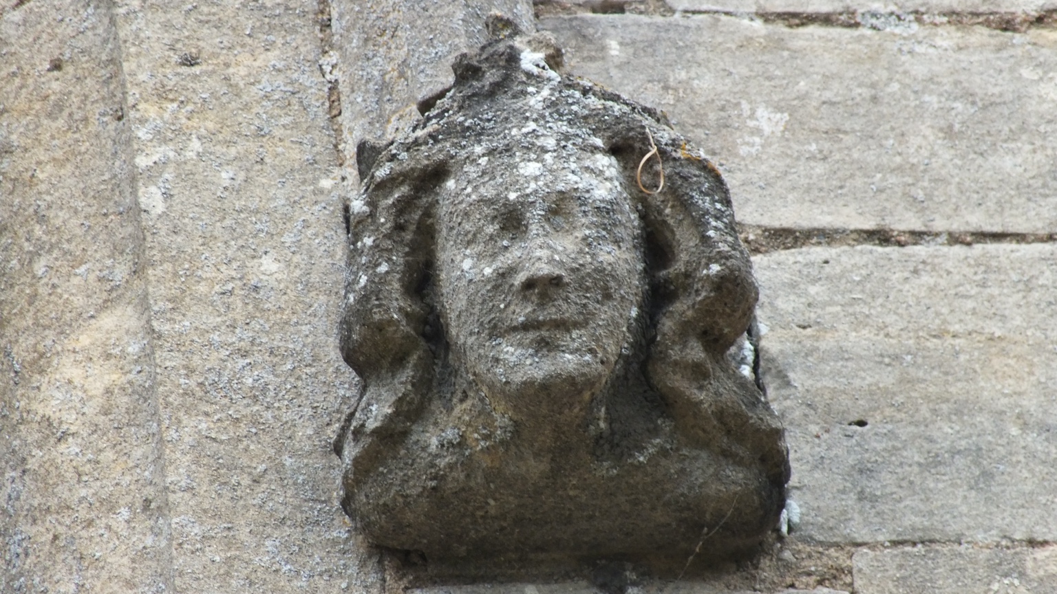 Weathered crowned female head carved on the exterior of St Andrew’s Church, Heckington
